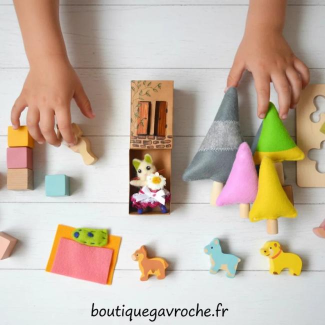 Chaton dans sa maison de carton et la forêt de sapin